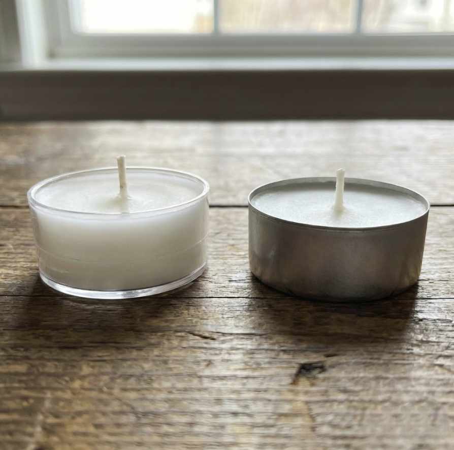 a comparison of two tealights in a polycarbonate cup and aluminium cup
